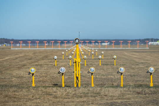 Airport approach lights in symmetrical runway alignment over open field, flight navigation, air traffic safety and aviation infrastructure concept