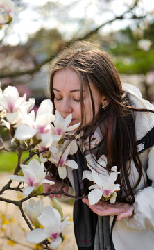 Woman enjoying cherry blossoms in a tranquil Japanese garden. Awakening of the nature.