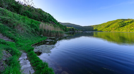 Fototapeta premium Beautiful lake with a green hill in the background