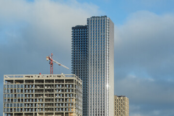 Fototapeta premium Construction of Modern Buildings in a City Skyline With Clouds in the Background During Daytime