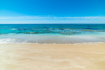 Obraz premium Empty beach with golden sand and clear turquoise water