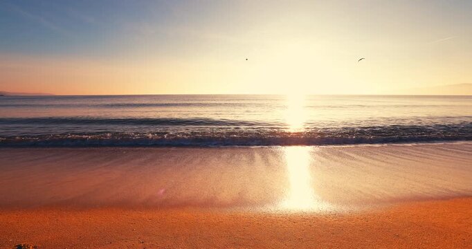 Golden ocean sunrise over tropical beach shore and rolling sea waves on the sand with soft sunlight summer vacation concept cinematic video