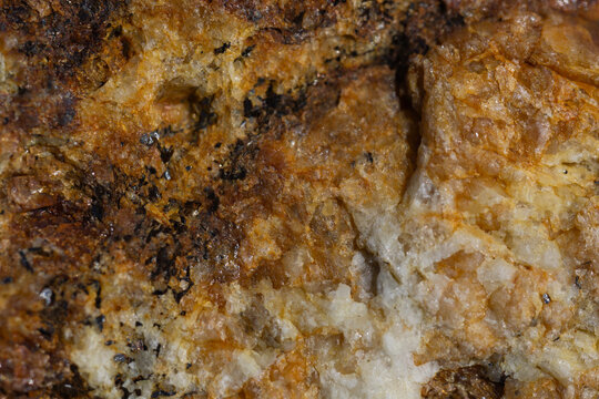 close up macro view of a natural mineral quartz texture with crystalline surface showing brown orange and white crystal patterns with dark inclusions