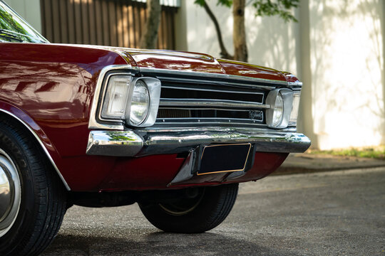 Dark red Chevrolet Opala front grille and headlight low angle, Classic retro car front end details