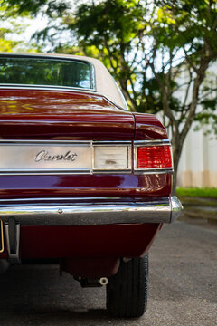 Burgundy Chevrolet Opala rear right taillight and badge, Classic vintage car rear end detail closeup