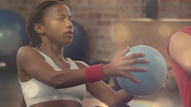 Animation of light spots over diverse people exercising at gym