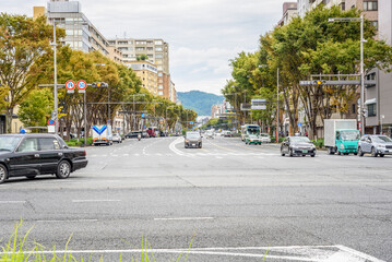 Crossroads at the end of a tree lined boulevard in kyoto city centre on a cloudy autumn day
