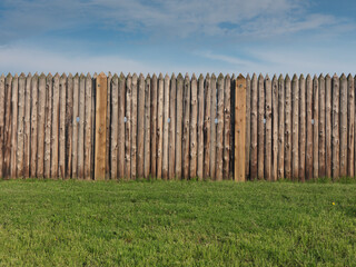 Fototapeta premium Historic old wooden palisade fence stakes, fenced fort wall.