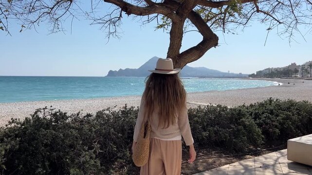 Mujer acariciando &aacute;rbol conectando con la naturaleza y el mar