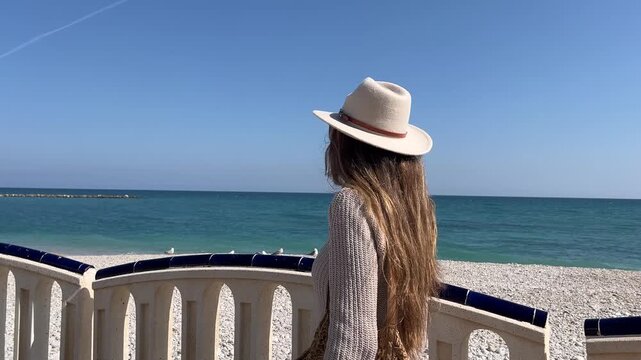 Push in suave hacia rostro de mujer caminando por paseo mar&iacute;timo