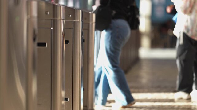 Commuters passing through subway station turnstiles