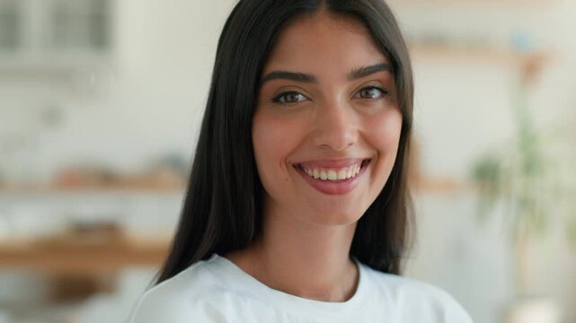 Happy smiling Indian woman at home looking at camera sending air kiss affectionate romantic gesture Arabian girl Latina female blowing kissing hand love support friendly beautiful lovely face indoors