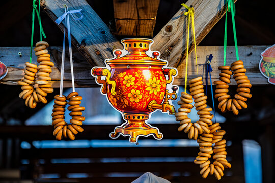 A painted samovar and bundles of bagels at a fairground stall
