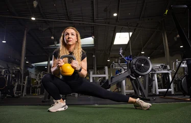 Fitness and health concept. A fit young woman works out in a modern gym. Athletic man doing exercise. © Lukas Gojda