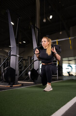 Fototapeta premium Fitness and health concept. A fit young woman works out in a modern gym. Athletic man doing exercise.