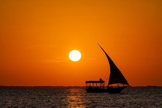 Tanzania, Zanzibar, Kendwa - 5 December 2025 - The enchanting sunset glow over a traditional dhow sailing the sea