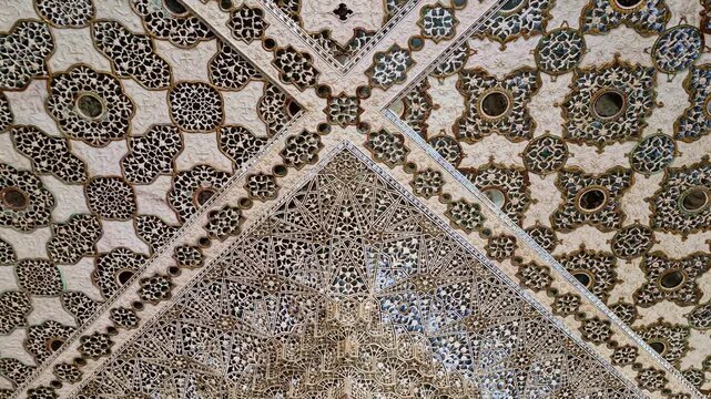 Showing the highly detailed mirror mosaic ceiling of Sheesh Mahal in Amer Fort, with intricate geometric patterns, floral designs, and tiny glass inlays reflecting light in Rajput�Mughal style.