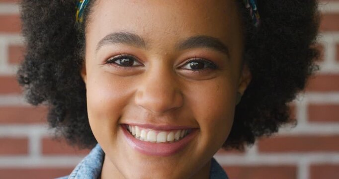Education, face and smile of student black girl on brick wall background for learning or study. Development, knowledge and scholarship with happy African person on college or university campus