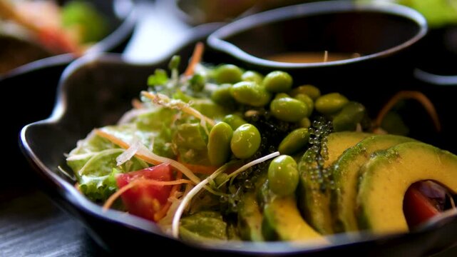 Poke bowl with salmon, rice, avocado, edamame beans, cucumber and radish in gray bowl. Hawaiian ahi poke bowl, gray background.