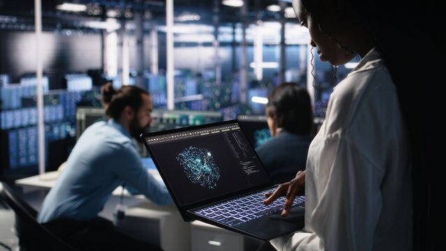 Close up of data center technician using tablet to monitor neural network AI LLM visualization. Worker using large language model on device to oversee servers powering machine learning, camera A