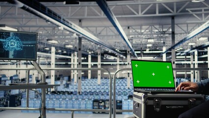 Fototapeta premium Data center employees check AI dashboard using green screen laptop during systems review. Server hub workers test artificial intelligence tools on mockup notebook for reliable performance, camera A