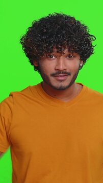 Ambitious satisfied egoistic young Indian man winner of lottery posing for photographers, successful famous rich person. Celebrating success, winning. Hindu boy isolated on green chroma key background
