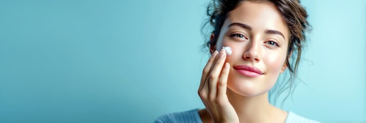 Fototapeta premium Woman touching cheek with moisturizing cream, minimal skincare close-up