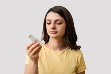 Fototapeta premium Female holding asthma inhaler for respiratory treatment and asthma control.