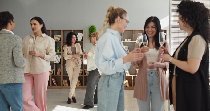 Women business networking colleagues communication teamwork office mingling. Groups mingle in an office party, discussing ideas to build trust. Workplace unity and lasting success concept.