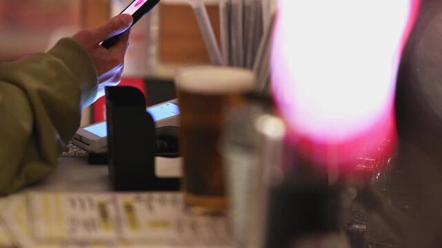 Person using a smartphone for contactless payment in a restaurant