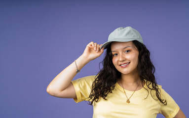 Naklejka premium Young woman smiling, adjusting her casual baseball cap