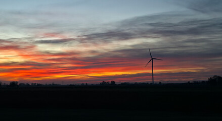 Obraz premium Wind turbines against the backdrop of a colorful picturesque sunset. Alternative eco-friendly sources of electricity