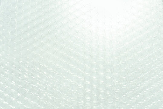 Bubble wrap close up with strong backlight. Fragile, protective and tactile, evoking plastic culture, sensory fidget relief, repetition, vulnerability, little pleasures and personal bubble.