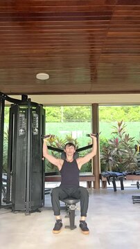 homem faz exerc&iacute;cios fis&iacute;cos em academia 