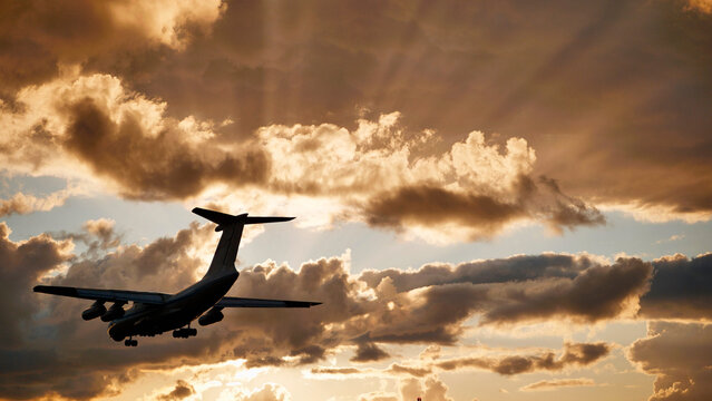 Russian ilyushin il-76 cargo airplane landing at sunset