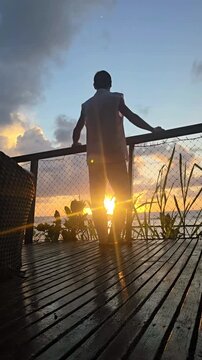 homem comtemplando praia em  paraiso 