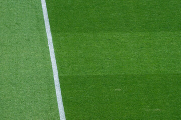 Obraz premium Background Texture of International-Standard Football Pitch with Striped Grass and Field Lines Under Clear Conditions