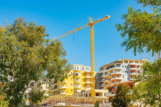 Yellow tower crane construction site new residential apartment buildings in Vlora, Albania, urban development, Contemporary Modern residential buildings facade apartment buildings city lifestyle