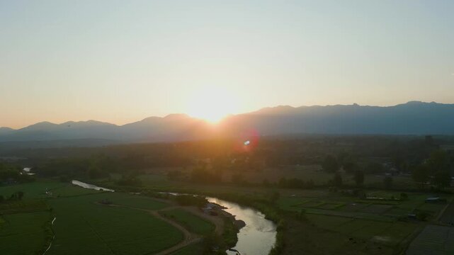 Aerial 4K of a peaceful river winding through the valley at sunset, Pai, Thailand