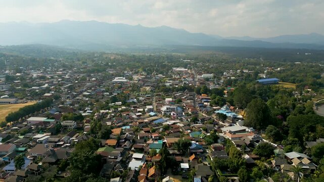 Aerial 4K of a traditional Thai village nestled in the green valley of Pai, Thailand