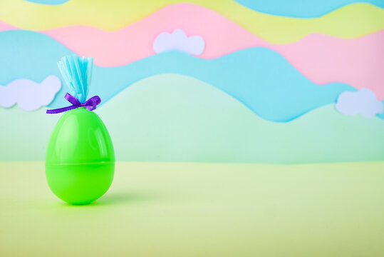 Single green easter egg with gift wrapping on pastel background with clouds minimal spring holiday concept with copy space.