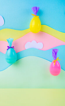 Bright easter eggs suspended on pastel layered background with clouds festive spring decoration minimal creative banner design.