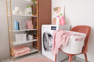 Interior of laundry room with washing machine, shelf unit and chair
