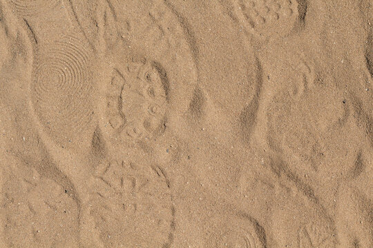 Footprints and shoe prints on sand texture background