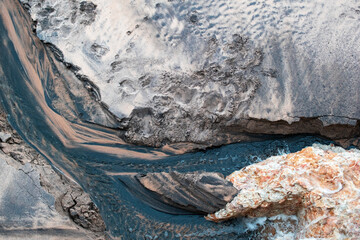 Muddy Stream Flowing Through Sandy Eroded Banks in Nature