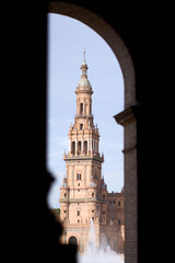 Fototapeta premium Giralda Bell Tower of Seville Cathedral Framed Through Historic Archway Spain