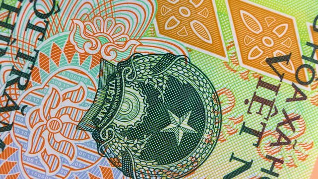 A macro, rotating view of the Vietnamese National Emblem on a banknote, showcasing intricate green details, a central star, and colorful, geometric security patterns in a fluid, high-quality close-up.