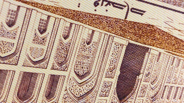 Macro shot of a 1,000 Iraqi Dinar bill featuring the historic Mustansiriya Madrasah. Detailed view of the banknote's texture, Arabic script, and architectural engraving for financial or cultural use.