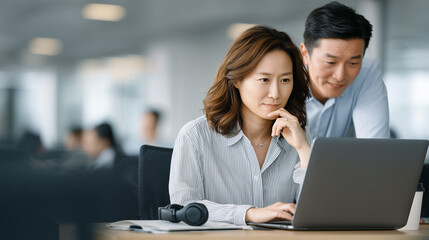 Fototapeta premium Focused Collaboration: A professional woman and man engage in a collaborative work session, absorbed in their task, and enhancing their analytical thinking
