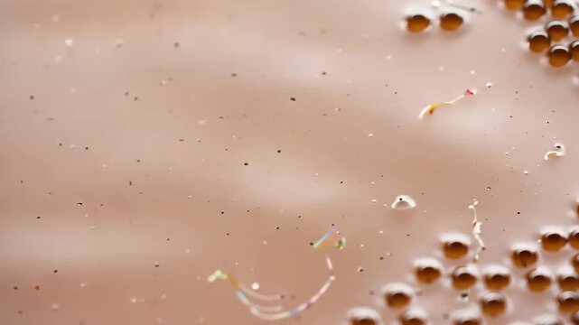 Close-up of bubbles and microplastics floating in brown murky water highlighting pollution and environmental issues